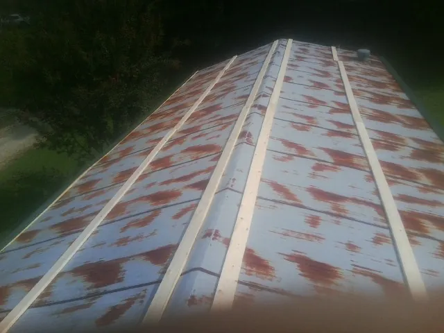 Rusted metal roof panels with new wood purlins before replacement — Storm Damage Roof Repair in Pledger by Roofing Brothers